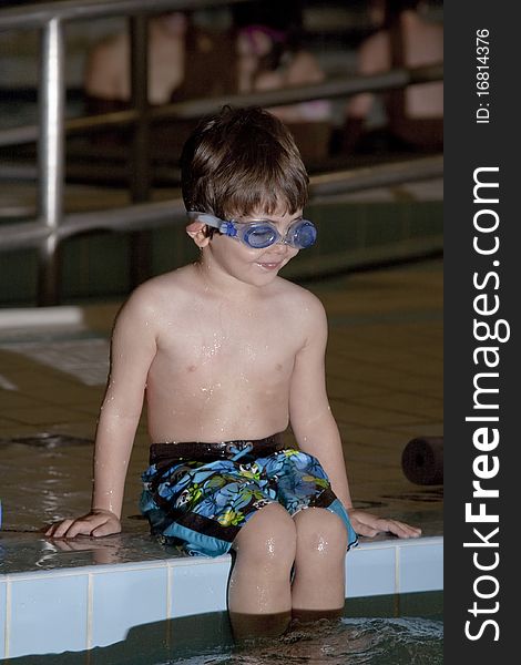 A boy taking a swim lesson at an indoor pool