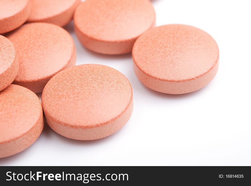 Close-up of orange pills, isolated on white, selective focus. Close-up of orange pills, isolated on white, selective focus