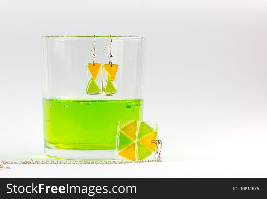 Glass earrings and pendant together with glass of green lemonade