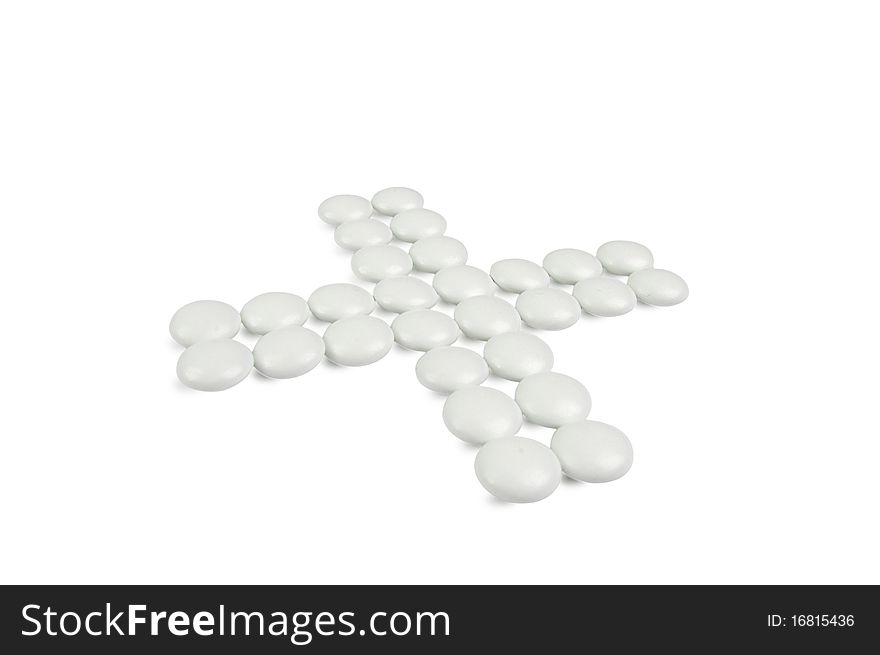 Cross-shaped group of pills isolated on white