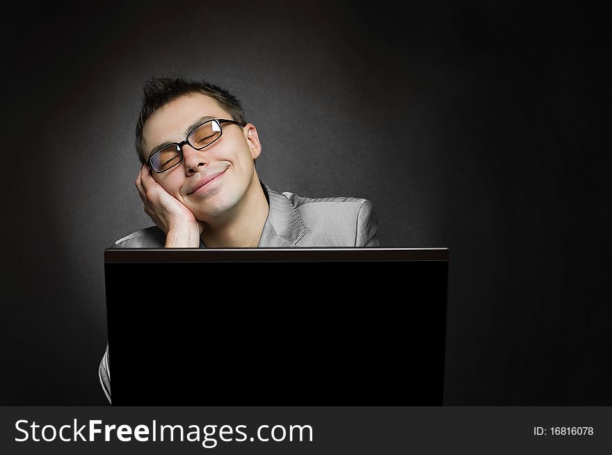 Dreaming businessman with laptop on black background