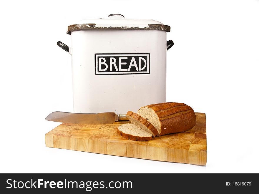 A white vintage bread tin with bread and a knife on a wooden board isolated on a white background