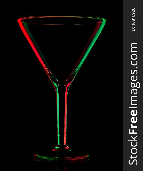Transparent colored empty martini glass on black
