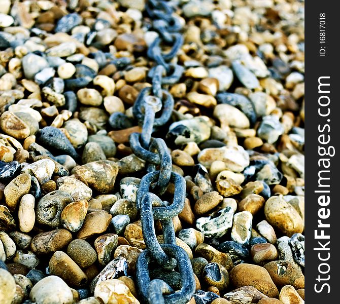 A chain lying on a pebbled beach. A chain lying on a pebbled beach