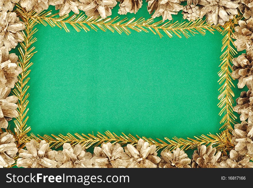 Green christmas background with gold cones frame
