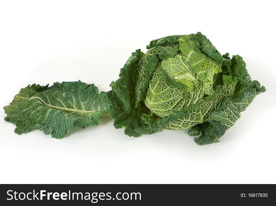 A head of savoy cabbage with leaves on white background