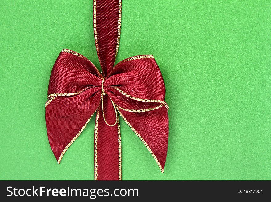 Gift in green wrapping with a red bow in close up. Gift in green wrapping with a red bow in close up