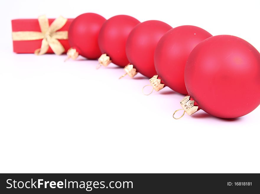Red matt christmas balls and a gift in red wrapping on white background, with space for your text. Red matt christmas balls and a gift in red wrapping on white background, with space for your text