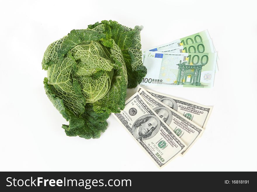 A head of savoy cabbage with three one hundred dollar and three one hundred euro banknotes on white background. A head of savoy cabbage with three one hundred dollar and three one hundred euro banknotes on white background