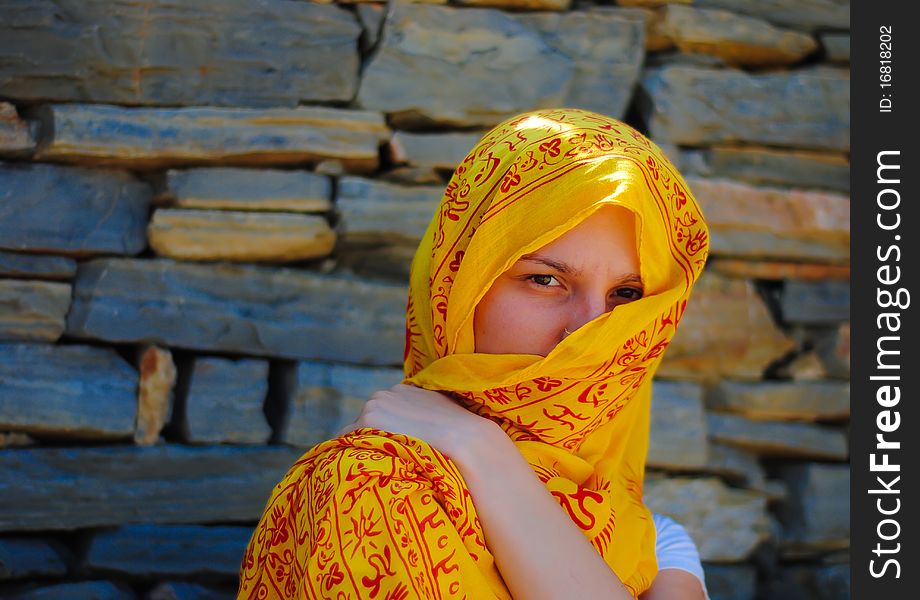 Young woman with yellow veil covering her face