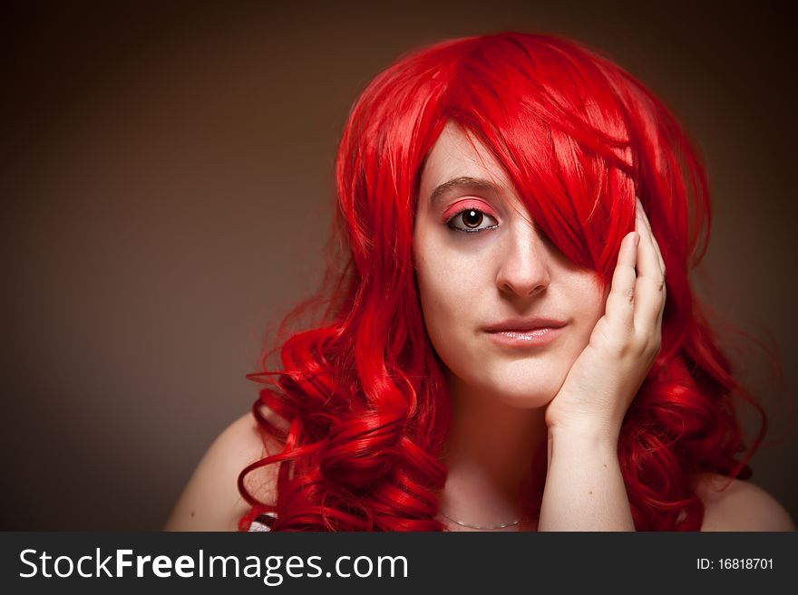 Attractive Red Haired Woman Wearing Bunny Ear Hat on a Grey Background.