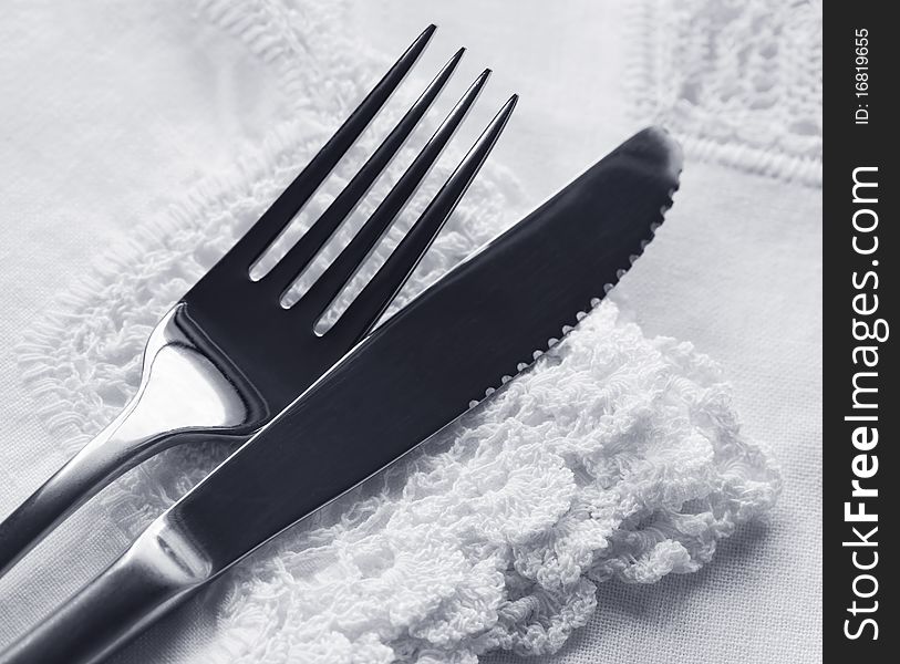 Knife and fork on lace napkin and tablecloth. Knife and fork on lace napkin and tablecloth.