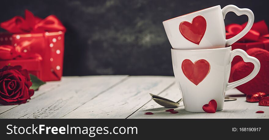 Valentine`s Day concept. Red Cups, gift boxes and roses on a Wooden Background. Love or Valentine`s Day Concept. Valentine`s Day concept. Red Cups, gift boxes and roses on a Wooden Background. Love or Valentine`s Day Concept.
