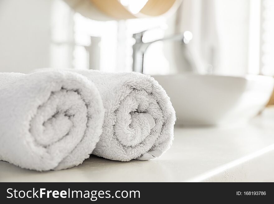 Clean rolled towels on countertop in bathroom