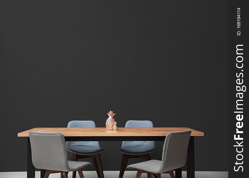 Modern Table With Decorative Pineapples Near Wall