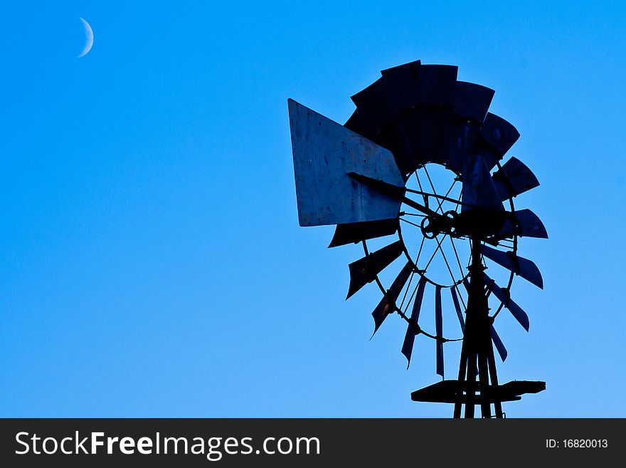 A crescent moon lighting a windmill. A crescent moon lighting a windmill.