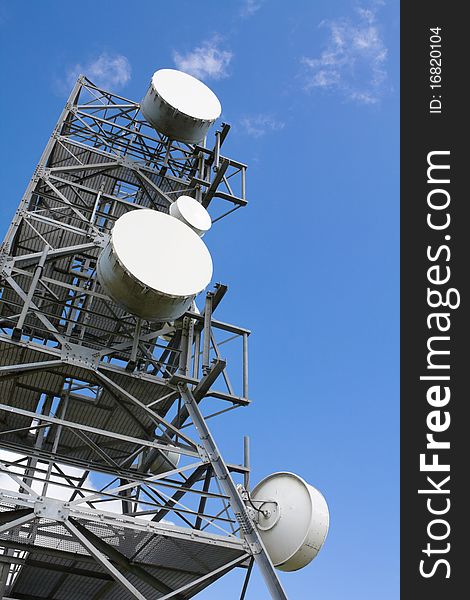 Communication tower on the blue sky background.