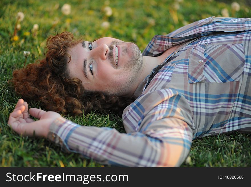 Man laying on the grass and smiling. Man laying on the grass and smiling