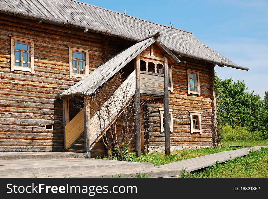 Traditional russian rural house at midday with green grass