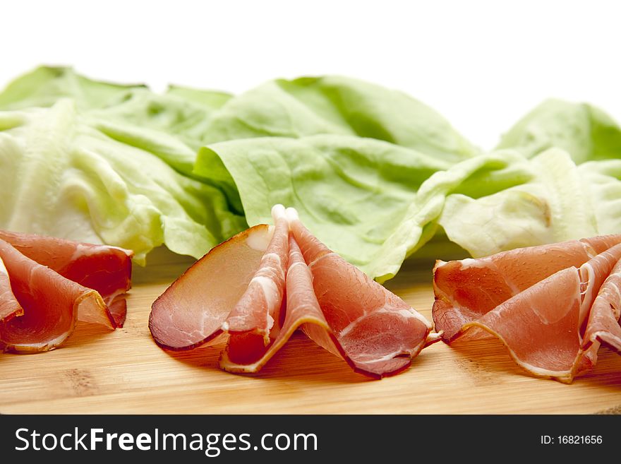 Sausage plate with raw ham and lettuce leaf. Sausage plate with raw ham and lettuce leaf