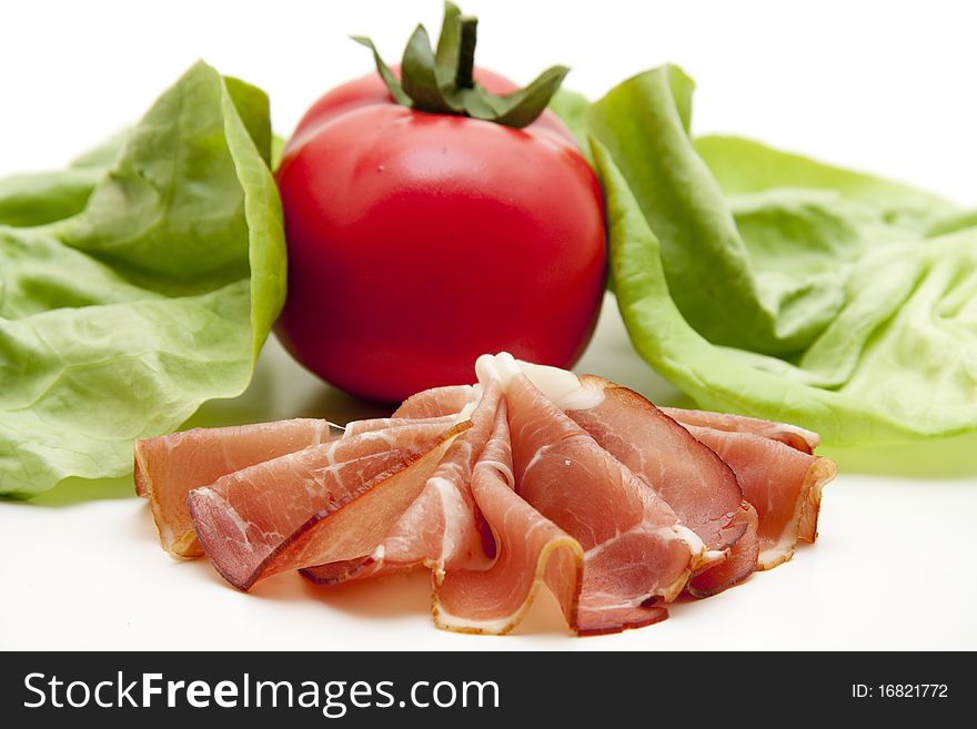 Plate with raw ham and tomato with salad