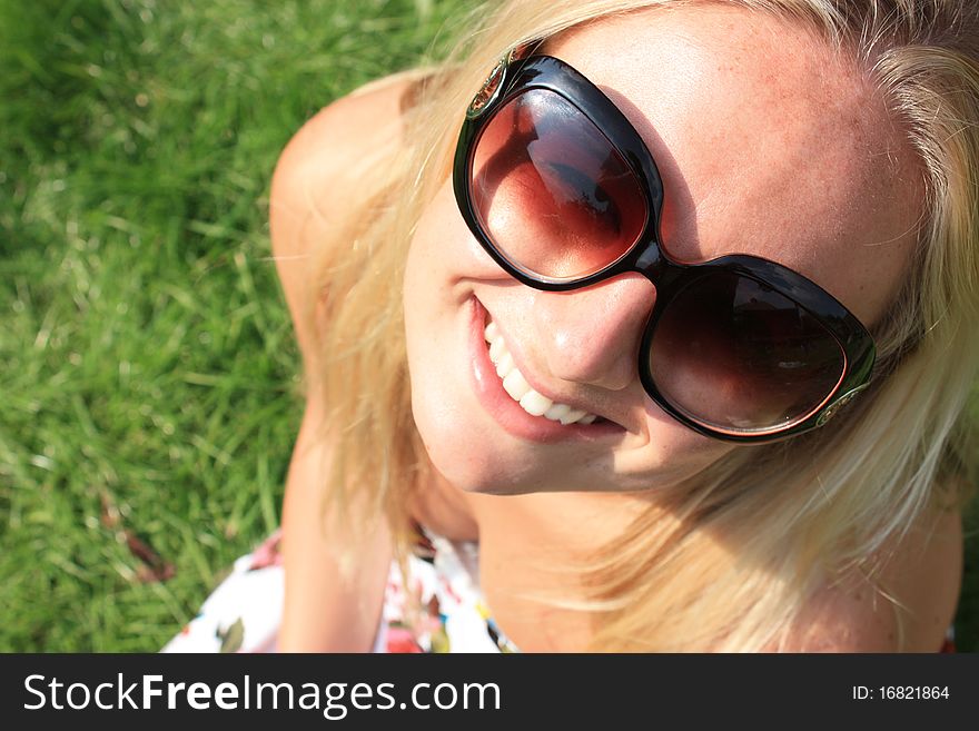 A pretty young woman tilting her head and smiling with glasses on. A pretty young woman tilting her head and smiling with glasses on