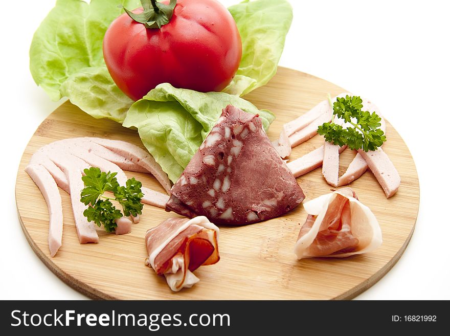 Mixed sausage plate with lettuce leaf and tomato. Mixed sausage plate with lettuce leaf and tomato