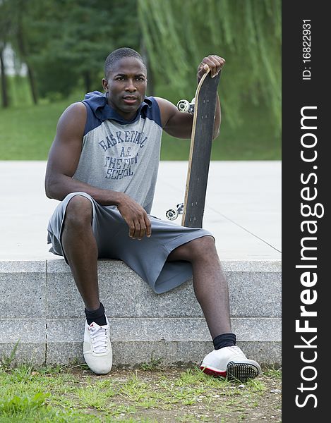 Young man with skateboard in a park