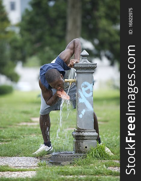 Young man drinking from a fountain. Young man drinking from a fountain