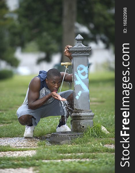 Young man drinking from a fountain. Young man drinking from a fountain