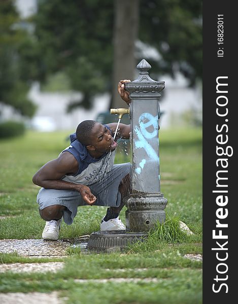 Young man drinking from a fountain. Young man drinking from a fountain