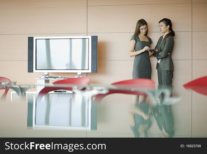 Businesswomen speaking, desk on foreground