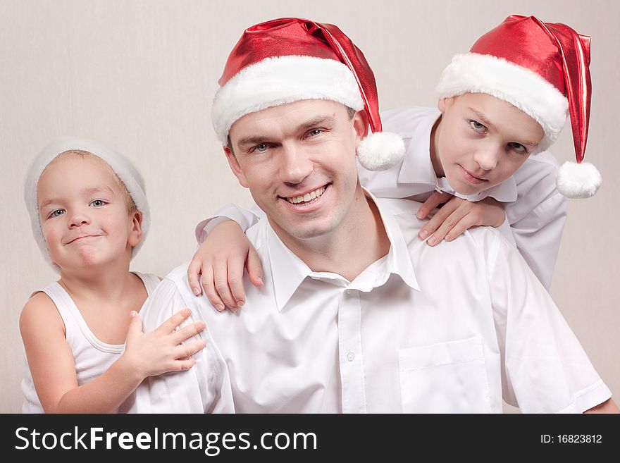 Happy and merry father and two sons in santa hat. Happy and merry father and two sons in santa hat