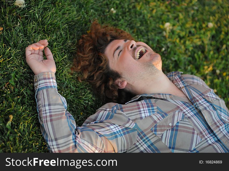 Man smiling and laughing laying on the grass. Man smiling and laughing laying on the grass