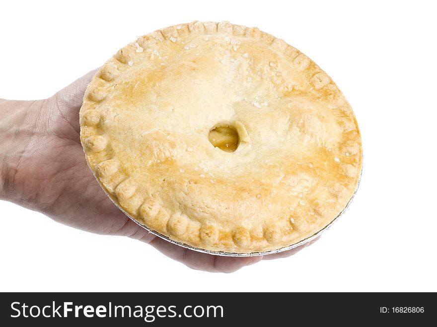 A man's hand holding an apple pie isolated on white.