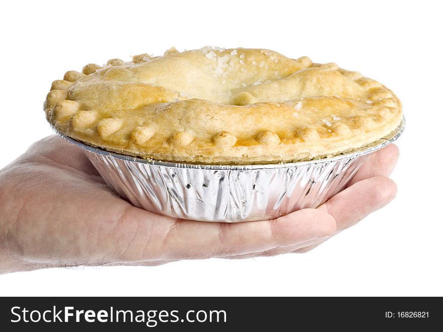 A man's hand holding an apple pie isolated on white.