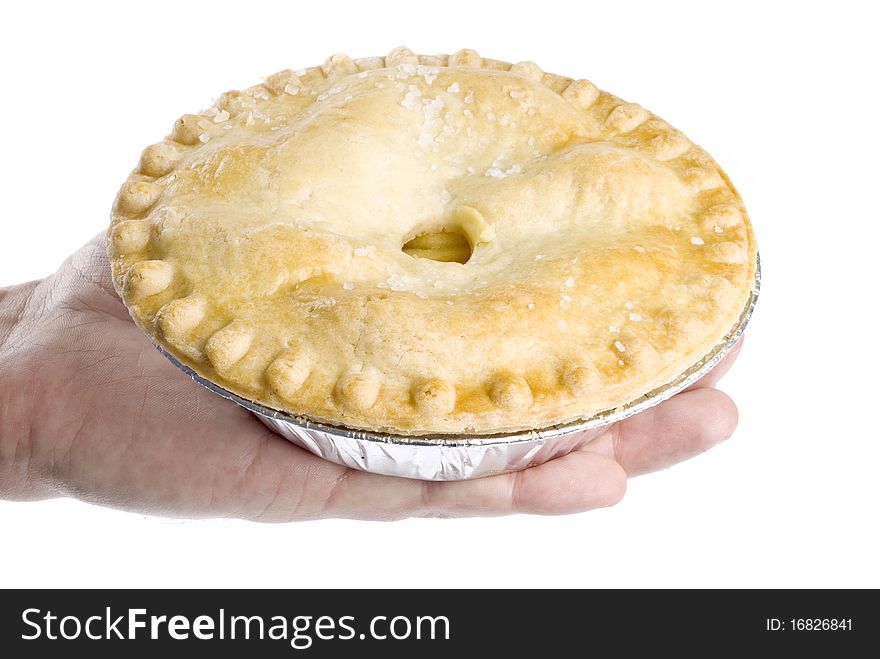 A man's hand holding an apple pie isolated on white.