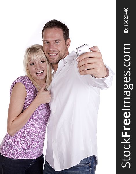 A couple taking a picture on his cell phone, she has her thumb up with happy smiles on their faces. A couple taking a picture on his cell phone, she has her thumb up with happy smiles on their faces.