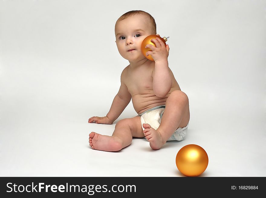 Baby playing with the Christmas glass ball on the white background. Baby playing with the Christmas glass ball on the white background