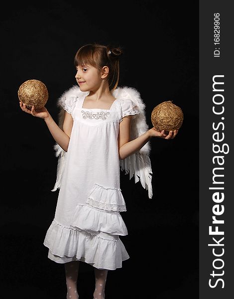 Girl playing with the Christmas glass ball on the black background. Girl playing with the Christmas glass ball on the black background