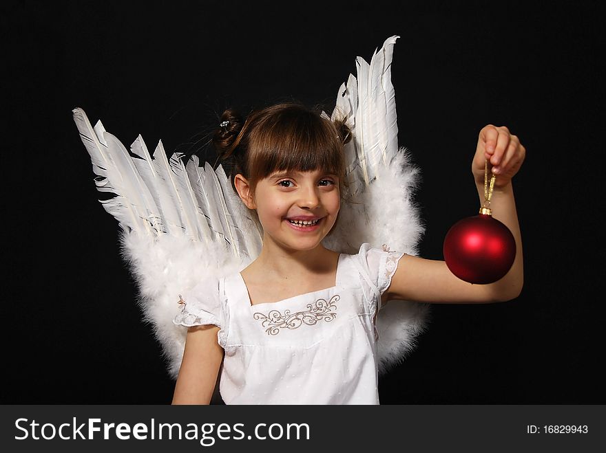 Girl playing with the Christmas glass ball on the black background. Girl playing with the Christmas glass ball on the black background