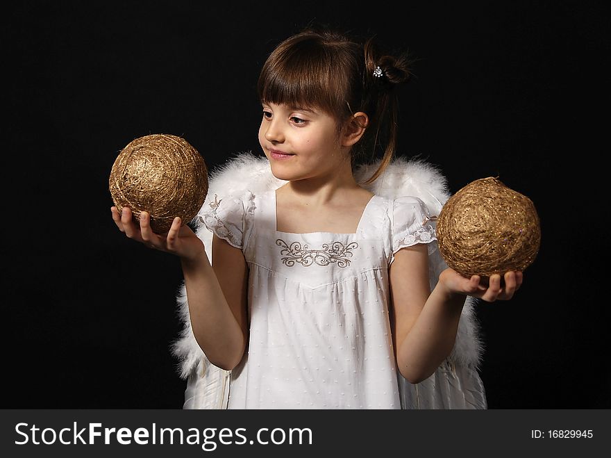 Girl playing with the Christmas glass ball on the black background. Girl playing with the Christmas glass ball on the black background