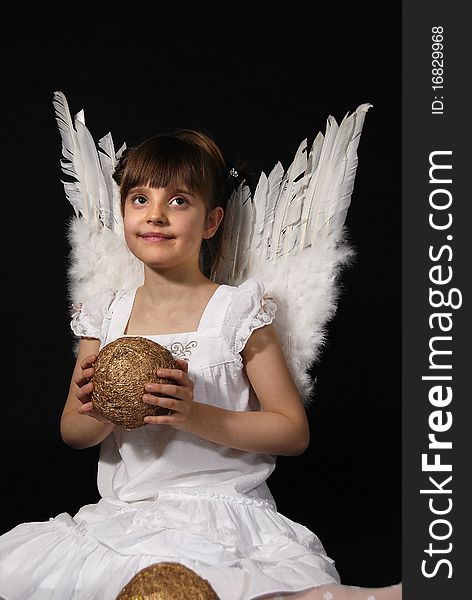 Girl playing with the Christmas glass ball on the black background. Girl playing with the Christmas glass ball on the black background