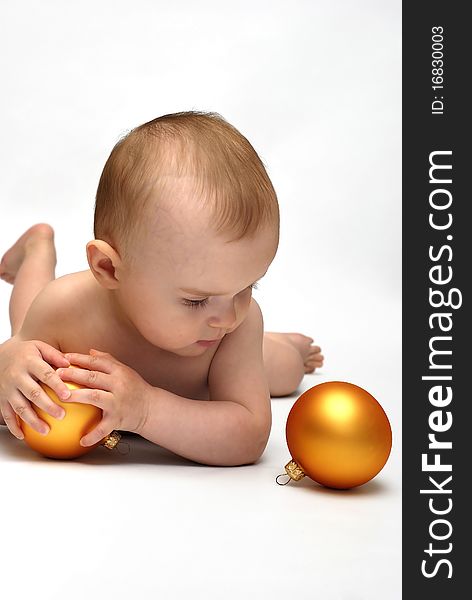 Baby playing with the Christmas glass ball on the white background. Baby playing with the Christmas glass ball on the white background