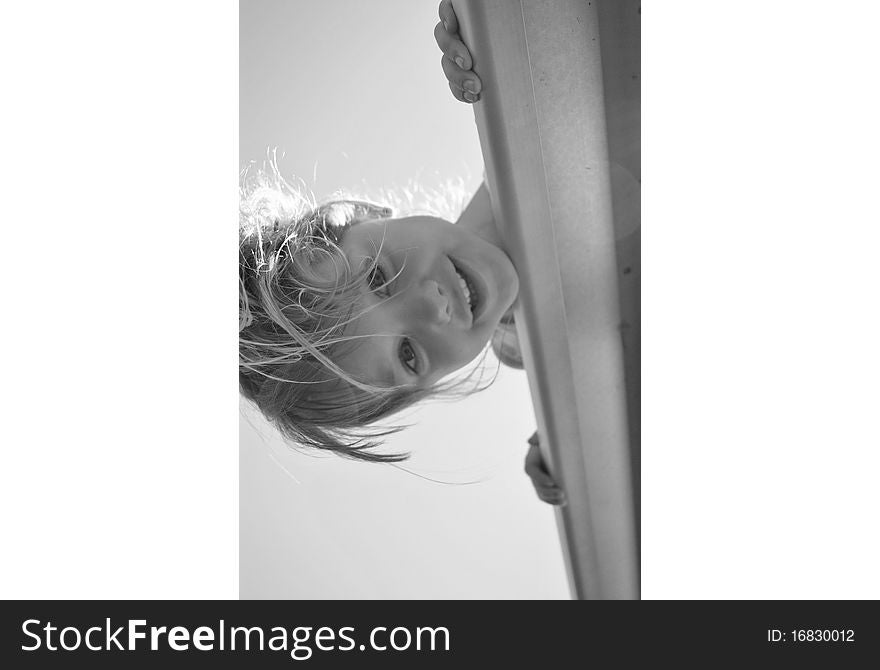 Summer day with a little girl leaning over a bleacher seat. Summer day with a little girl leaning over a bleacher seat