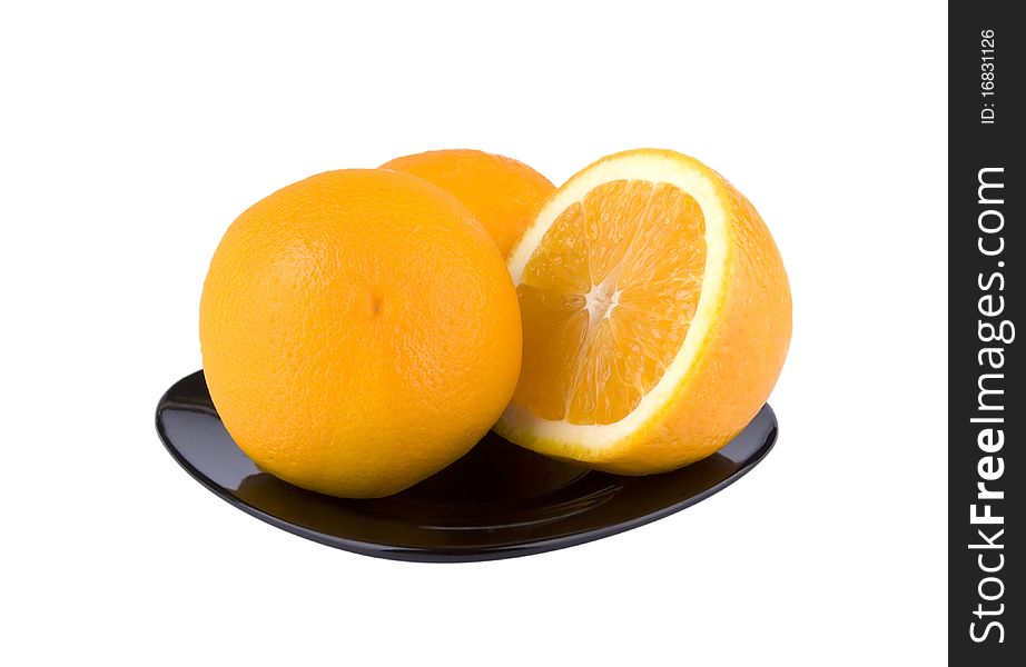 The beautiful cut fruit of an orange on a black plate. The beautiful cut fruit of an orange on a black plate