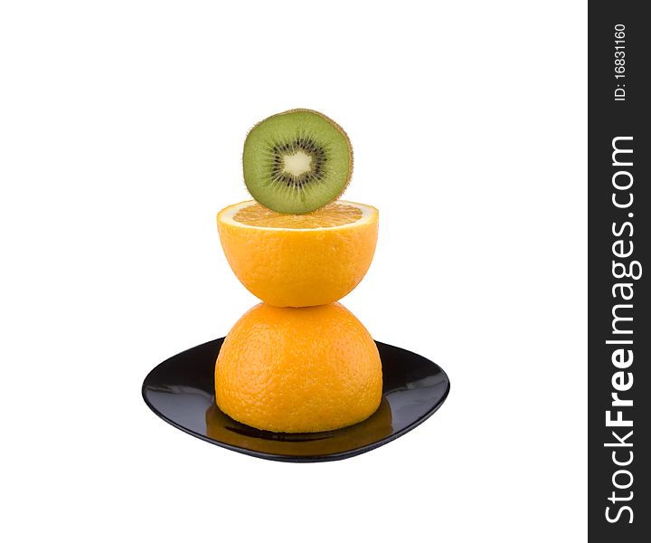The beautiful cut fruit of an orange on a black plate. The beautiful cut fruit of an orange on a black plate