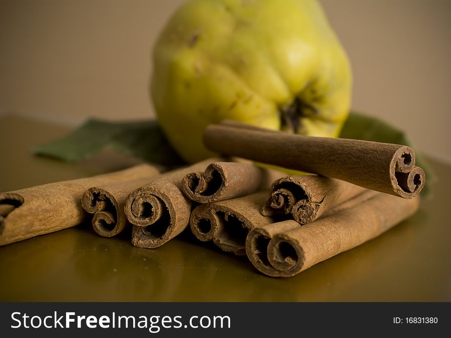 Cinnamon and apples on brown background