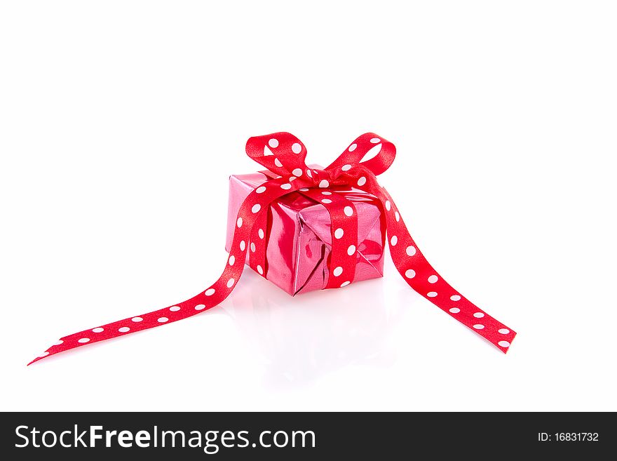 Red gift with a dotted ribbon isolated over white