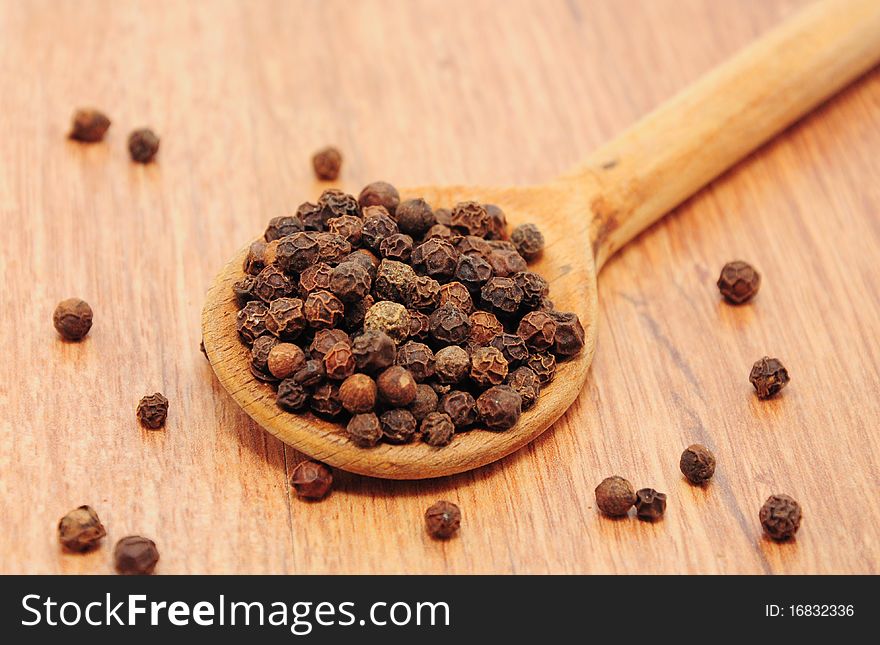 Peppercorns on the table in wooden spoons. Peppercorns on the table in wooden spoons